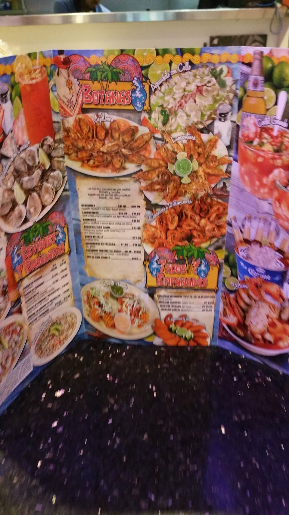 Printed menu with tacos, empanadas, and quesadillas.
